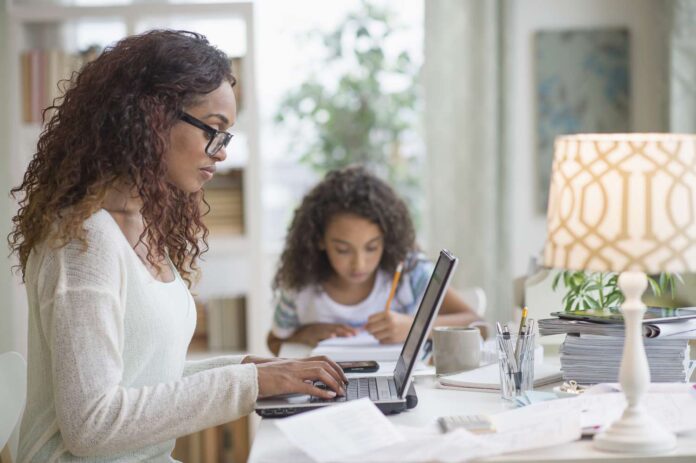 Woman looking at a laptop. Multitasking.