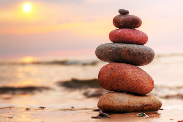Stones pyramid on sand symbolizing zen, harmony, balance. Ocean