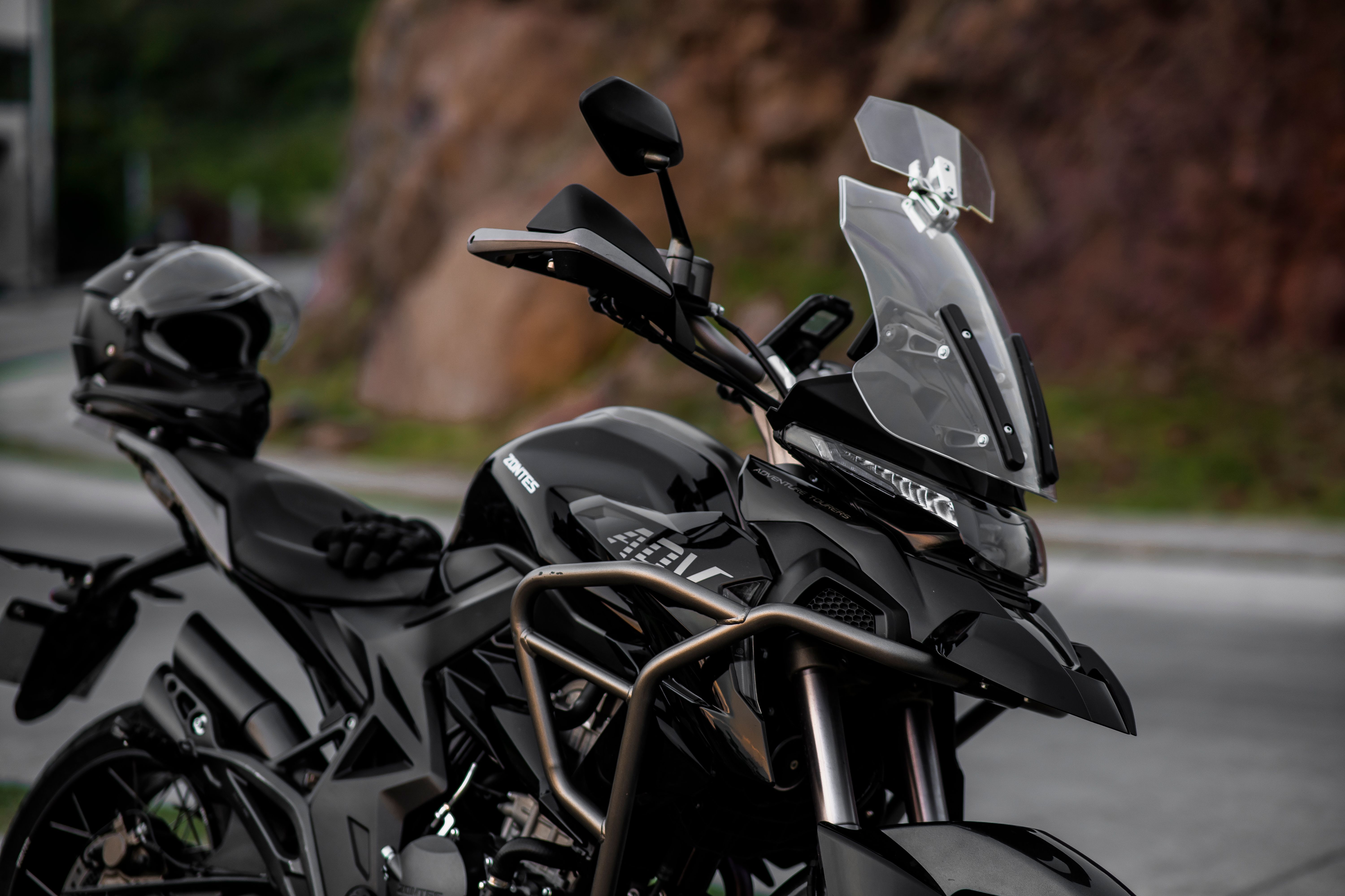 Close-up of a black adventure motorcycle with a tall windscreen parked outdoors