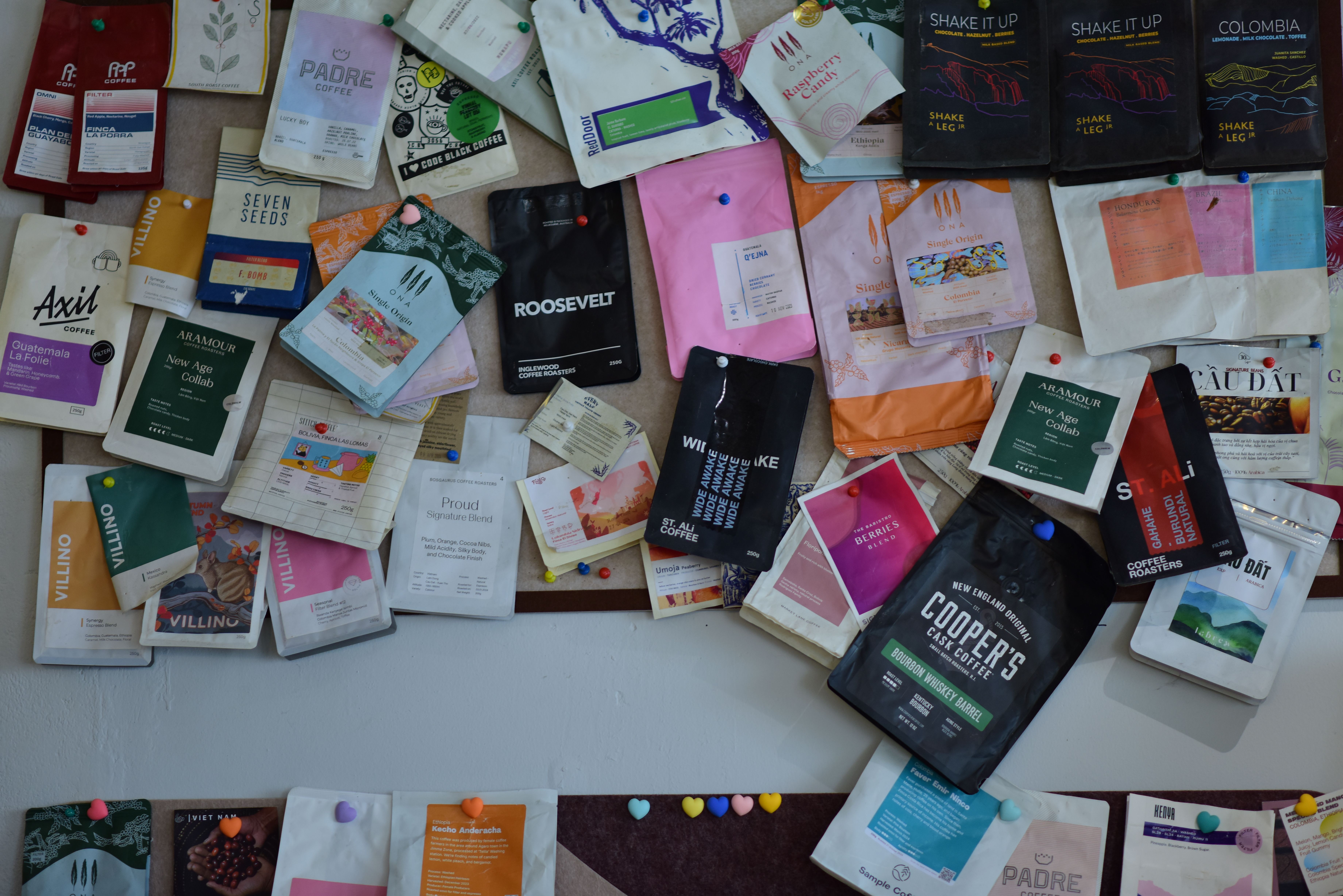 Variety of custom coffee packaging designs displayed on a wall, showcasing mylar bag customization options