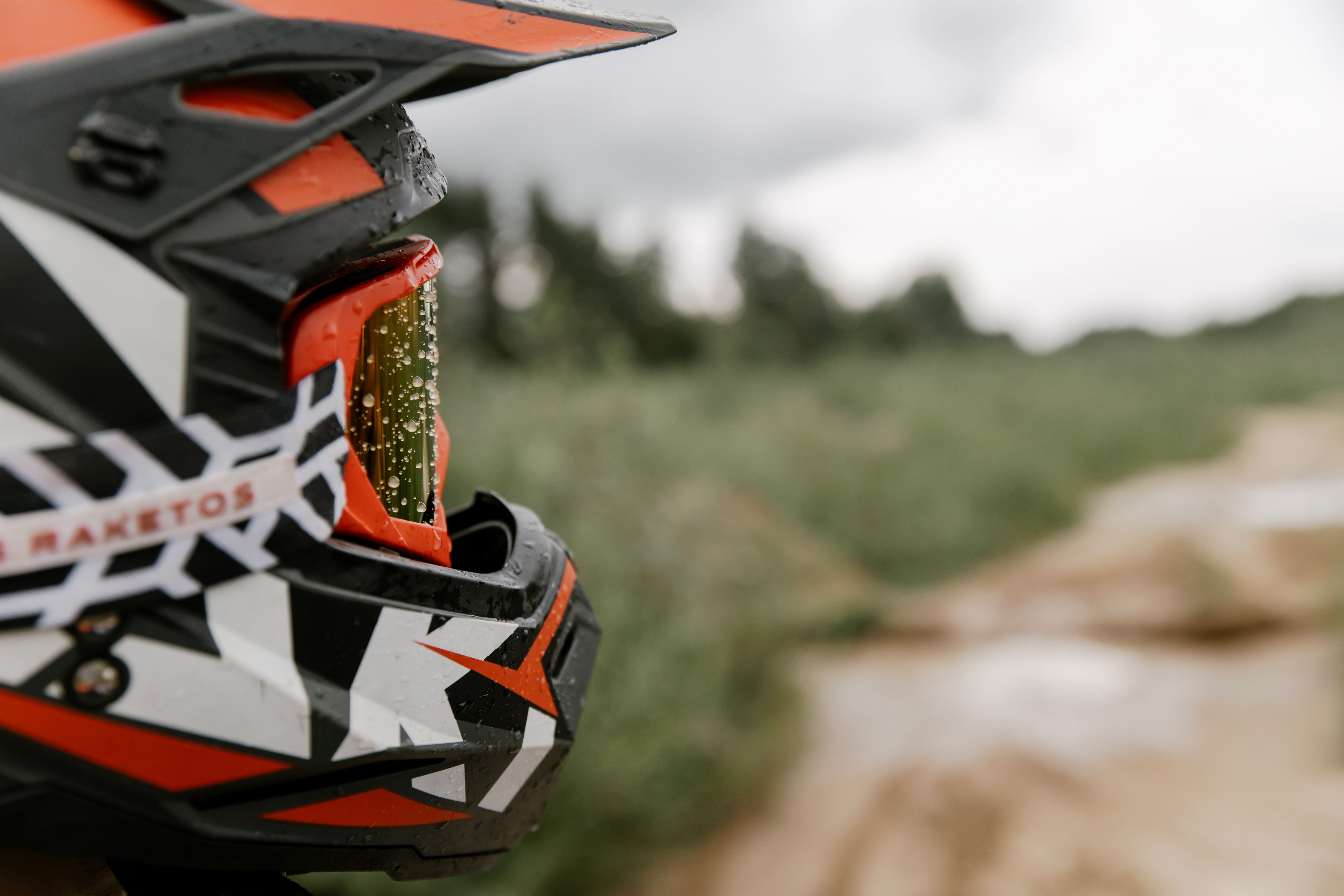 Close-up of a motorcycle helmet visor covered in rain droplets