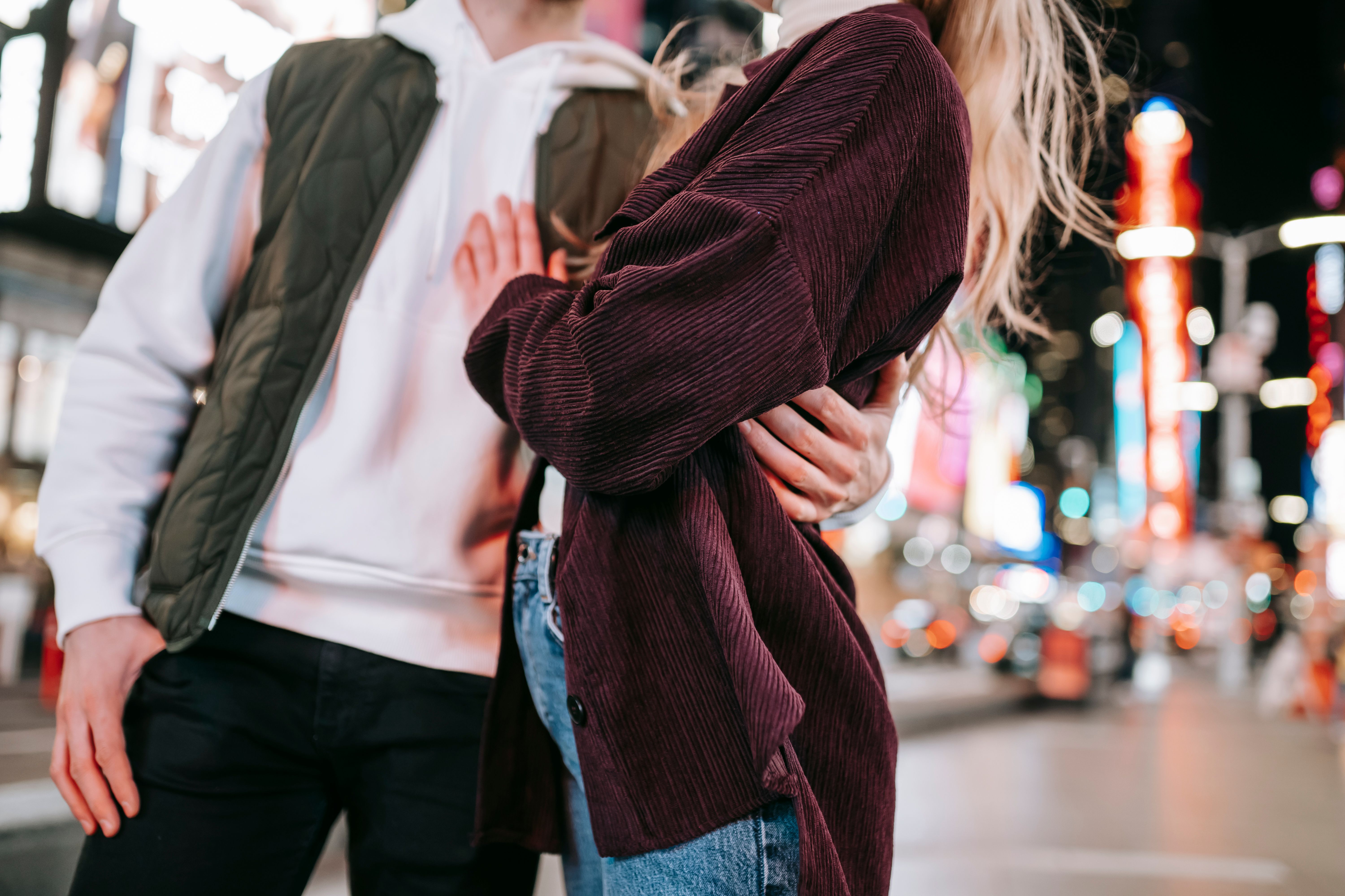 A couple embracing on a city street at night, illustrating romantic companionship